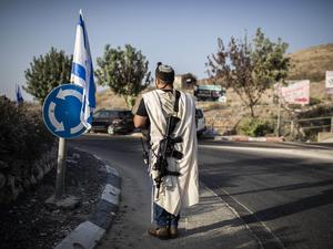Ein israelischer Siedler trägt eine Waffe am Haupteingang der palästinensischen Stadt Nablus im besetzten Westjordanland. 