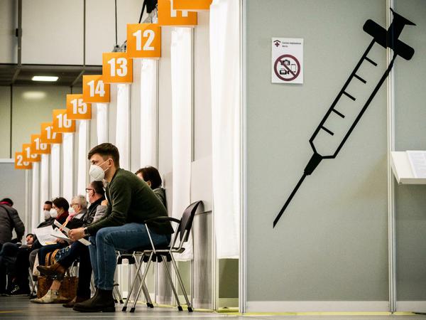 Menschen warten im Corona-Impfzentrum auf dem Messegelände auf ihre Impfung.