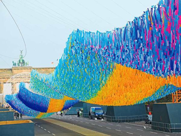 Vor dem Brandenburger Tor schwebt ein Kunstwerk aus 100 000 transparenten Bändern mit Wünschen und Botschaften vieler Menschen, speziell zum Thema Mauern und Grenzen. 