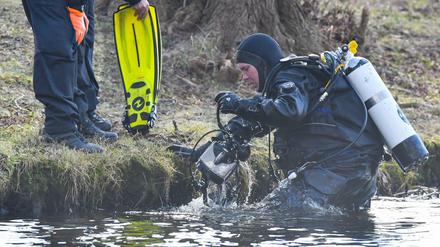 Ein Polizeitaucher kommt aus dem Wasser des Storkower Sees nahe der Mündung in den Wolziger See im Landkreis Dahme-Spreewald.