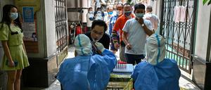 Ein Mann wird an einer Teststation in Shanghai auf das Coronavirus getestet.