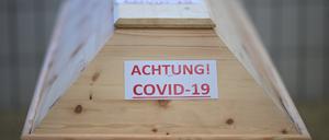 Ein Sarg mit der Aufschrift „Achtung! Covid-19“ steht in einem Raum im Krematorium, bevor der Sarg eingeäschert wird.