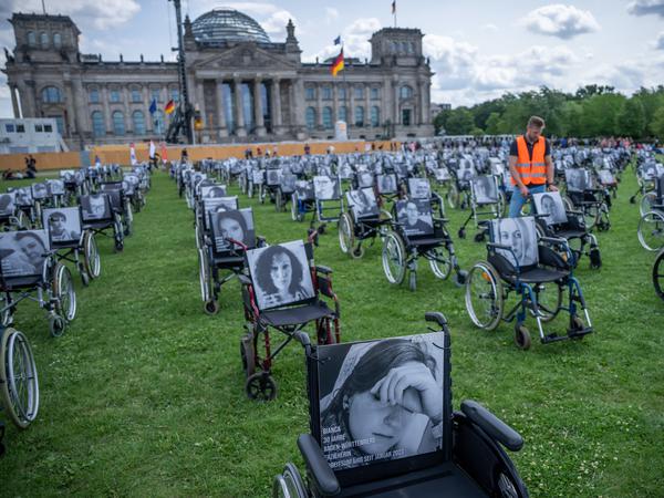 Rollstühle mit Bildern und Namen von Long-Covid-, ME-/CFS- und Post-Vac-Betroffenen erinnern vor dem Bundestag an die Schicksale von Langzeiterkrankten.
