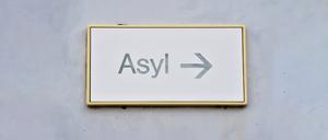 ARCHIV - 04.08.2014, Baden-Württemberg, Karlsruhe: Ein Schild mit der Aufschrift «Asyl» hängt in Erstaufnahme für Asylbewerber an einer Wand. (zu dpa: «Weniger Flüchtlinge in kommunalen Unterkünften») Foto: Uli Deck/dpa +++ dpa-Bildfunk +++