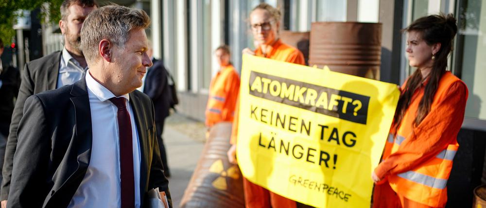 Da hatte er noch gut lachen: Wirtschaftsminister Robert Habeck geht auf dem Weg zur Vorstellung der Ergebnisse des Stresstests zum Weiterbetrieb von Atomkraftwerken an Demonstranten vorbei.