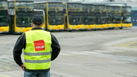 Ein Mann mit Verdi-Weste vor Bussen der BVG (Symbolbild).