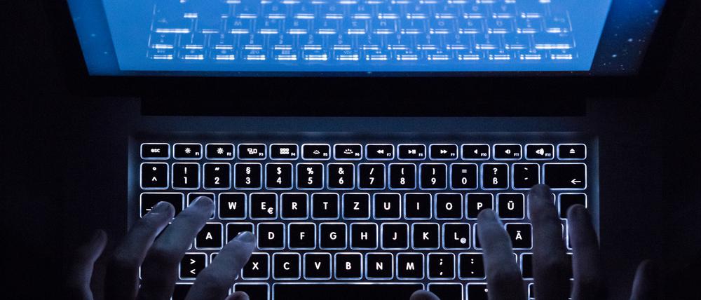 Ein Mann benutzt die beleuchtete Tastatur eines Notebooks.