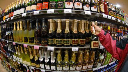 Ein Regal mit Sektflaschen und anderen alkoholischen Getränken in einem Supermarkt.