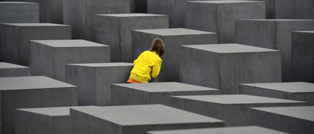Ein Kind spielt Verstecken am Denkmal für die ermordeten Juden Europas in Berlin-Mitte.