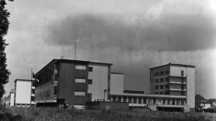 Das Bauhaus in Dessau in den 1930er Jahren, vor dem Gebäude hängt die Hakenkreuzfahne schlaff im Wind.