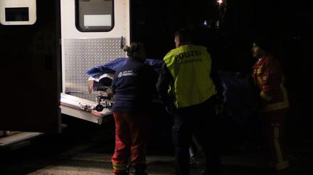 Einsatzkräfte bringen die Trage mit dem Leichnam des verunglückten E-Roller-Fahrers zum Krankenwagen. Ein E-Roller-Fahrer ist in Berlin-Marzahn unter eine Straßenbahn geraten und tödlich verletzt worden.