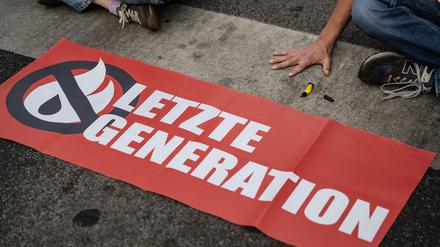 Ein Aktivist der Gruppe Letzte Generation, der seine Hand auf der Straße festgeklebt hat.