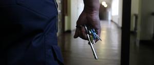 Eine Hand hält ein Schlüsselbund und im Hintergrund der Gang eines Gefängnisses verbrechen.