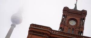 Der Fernsehturm steht am frühen Morgen hinter dem Roten Rathaus im Nebel.