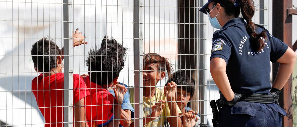Eine Polizistin spricht in einem Lager auf der griechischen Insel Lesbos mit Flüchtlingskindern. 