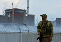 Ein Soldat mit einer russischen Flagge auf seiner Uniform hält vor dem Kernkraftwerk Saporischschja Wache (Symbolbild) Foto: REUTERS/Alexander Ermochenko