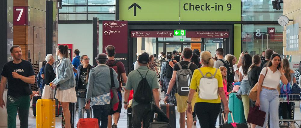 Reisende gehen auf dem Flughafen Berlin Brandenburg BER «Willy Brandt» am ersten Sommerferientag in Berlin und Brandenburg durch Terminal 1.