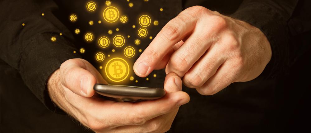 Hand holding smart phone mobile with bitcoin currency symbol