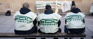 Teilnehmer eines Warnstreiks der Gewerkschaft Deutscher Lokomotivführer (GDL) im Jahr 2022 sitzen vor dem Heilbronner Hauptbahnhof auf einer Bank.