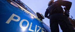 ILLUSTRATION - 30.11.2023, Baden-Württemberg, Stuttgart: Eine Polizistin steht im Rahmen eines Fototermins neben einem Polizeifahrzeug (gestellte Szene). (zu dpa: «Mann tötet 37 Jahre alten Mainzer») Foto: Marijan Murat/dpa +++ dpa-Bildfunk +++