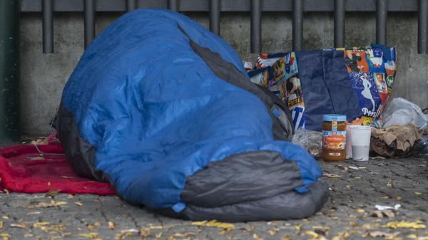 Ein Obdachloser liegt am 22.10.2015 in Berlin in einem Schlafsack gehüllt unter einem Dachvorsprung vor dem Zoo. 