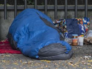 Ein Obdachloser in einen Schlafsack gehüllt unter einem Dachvorsprung vor dem  Berliner Zoo. 