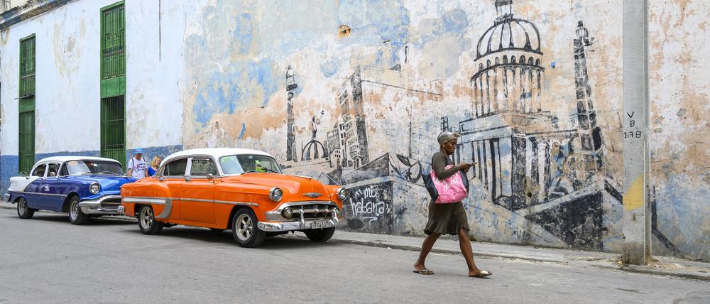 Old American Cars and wall mural of Havana, Cuba PUBLICATIONxINxGERxSUIxAUTxHUNxONLY acp132492 ChrisxCheadle