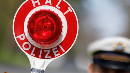 ARCHIV - 21.04.2023, Bayern, Nürnberg: Ein Polizist zieht ein Fahrzeug mit seiner Kelle aus dem Verkehr. (zu dpa: «Polizei zu «Carfreitag»: Autofans haben sich an Spielregeln gehalten») Foto: Daniel Karmann/dpa +++ dpa-Bildfunk +++