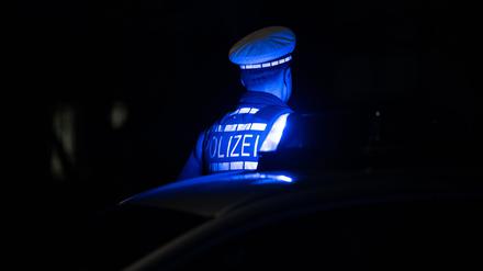 ILLUSTRATION - 30.11.2023, Baden-Württemberg, Stuttgart: Ein Polizist steht neben einem Polizeifahrzeug. (zu dpa: «Verdächtige nach Stichattacke auf 21-Jährigen ermittelt») Foto: Marijan Murat/dpa +++ dpa-Bildfunk +++