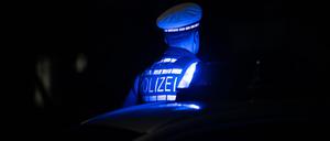 ILLUSTRATION - 30.11.2023, Baden-Württemberg, Stuttgart: Ein Polizist steht neben einem Polizeifahrzeug. (zu dpa: «Verdächtige nach Stichattacke auf 21-Jährigen ermittelt») Foto: Marijan Murat/dpa +++ dpa-Bildfunk +++