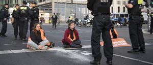 Polizisten stehen am Potsdamer Platz vor Aktivisten der Klimaschutz-Gruppe Letzte Generation. 