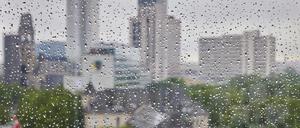 Regentropfen sind an einer Fensterscheibe vor der Skyline der City West zu sehen.