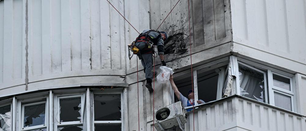 Ein Spezialist inspiziert die beschädigte Fassade eines mehrstöckigen Wohnhauses nach einem Drohnenangriff in Moskau: