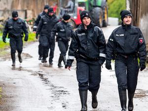 Polizisten und Polizistinnen gehen auf der Suche nach dem vermissten Arian aus Bremervörde über ein landwirtschaftliches Gelände.