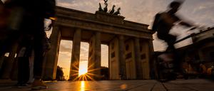Die Sonne geht hinter dem Brandenburger Tor unter.
