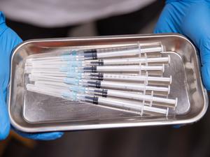 Aufgezogene Spritzen mit Impfstoff gegen Covid-19 liegen in einem temporären mobilen Impfzentrum in einer Schale.