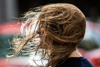 Sturmtief "Kirsten" lässt dieser Frau bei ihrem Weg durch in der Innenstadt die Haare ins Gesicht wehen. Foto: Boris Roessler/dpa