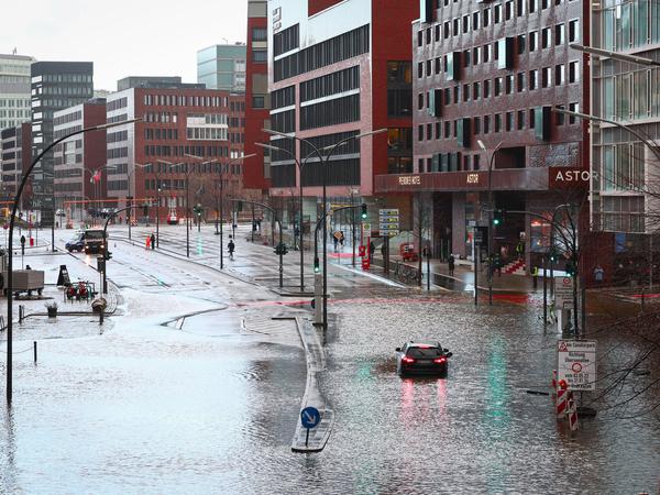 Ein Fahrzeug steckt auf der überschwemmten Straße in der Hafencity in Hamburg fest. 