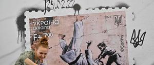 Widerstand steckt in der kleinsten Geste. Eine Ukrainerin fotografiert in Kiew Banksys jüngsten Streich.