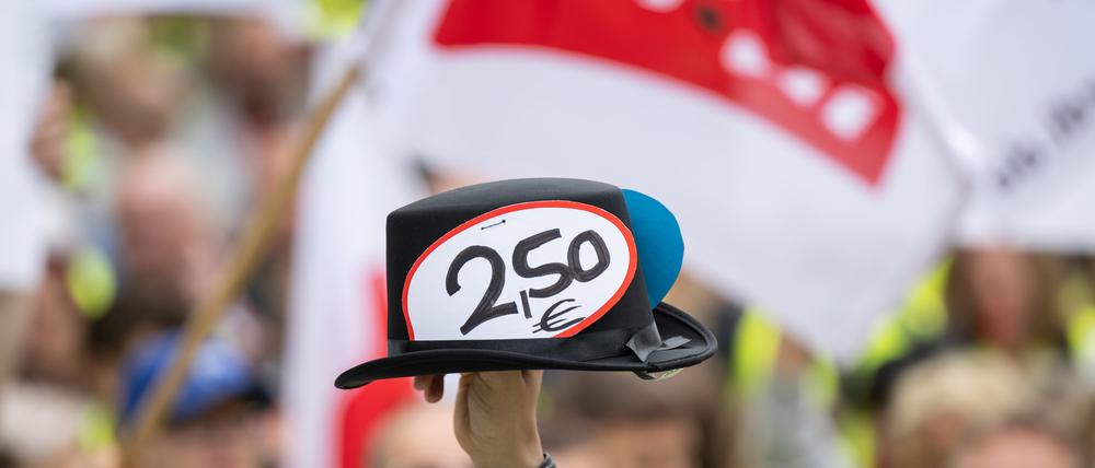 Ein Hut mit Sticker „2,50“ wird während einer Verdi-Kundgebung hochgehalten.