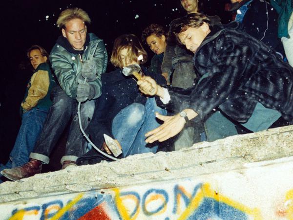 West-Berliner versuchen mit Hämmern und Kreuzhacken am 10. November 1989, die Berliner Mauer einzureißen.