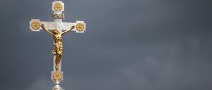 Ein Kruzifix ist vor dunklen Wolken zu sehen. (Symbolfoto)