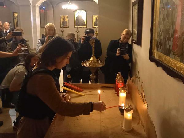 Außenministerin Annalena Baerbock entzündet eine Kerze für die Opfer in einer Kirche in Butscha.