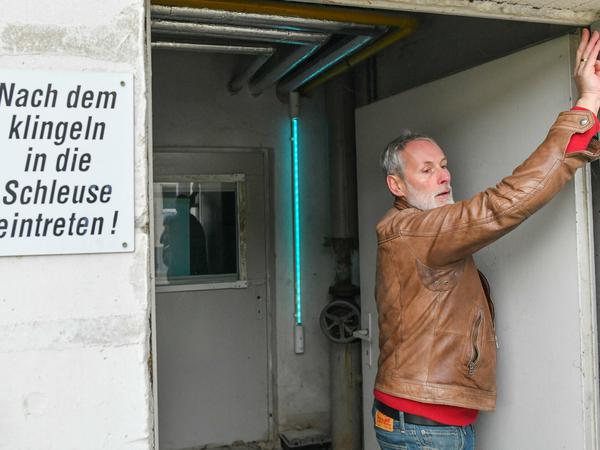 Hans-Christian Daniels, Chef vom Unternehmen Schweinezucht Lindenberg GbR, zeigt das UV-Licht in einer Schleuse zum Tierstall.