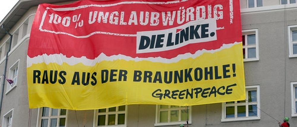 Greenpeace-Aktivisten seilen sich an der Parteizentrale der Linken in Berlin ab. Es geht - mal wieder - um die Braunkohle in Brandenburg.