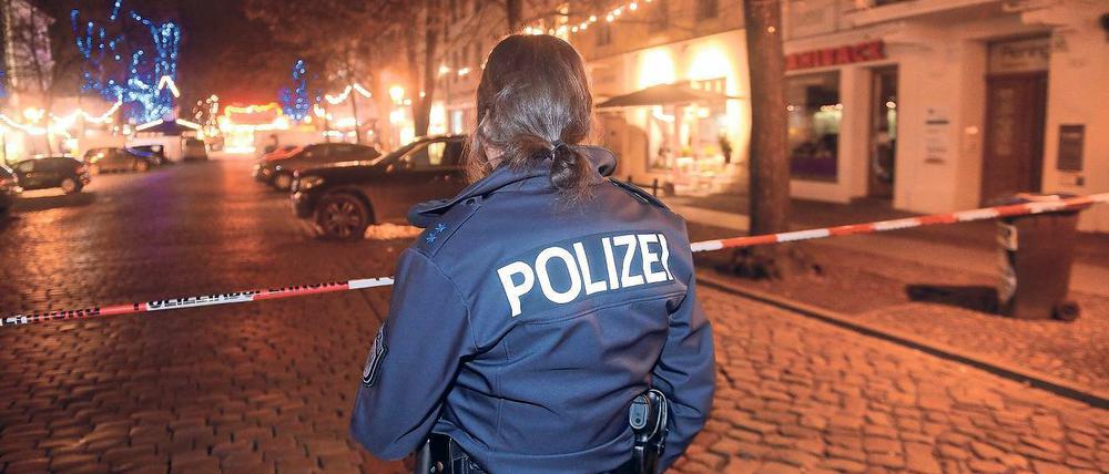 Im Dunkel. Am 1. Dezember 2017 sperrte eine Polizistin eine Straße in der Nähe des Weihnachtsmarkts in der Potsdamer Innenstadt ab, nachdem Bombenentschärfer ein verdächtiges Paket unschädlich gemacht hatten. Nach den Tätern wird fieberhaft gesucht.