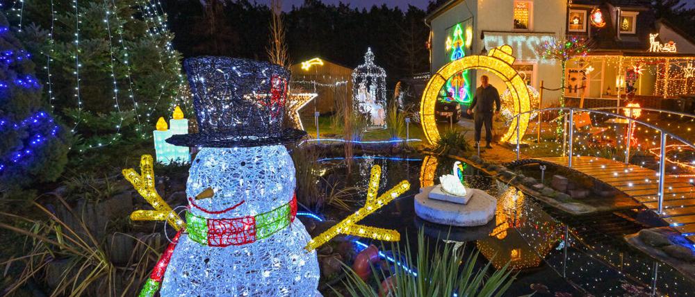 Harald Muschner steht in seinem weihnachtlich beleuchteten Garten. Lichterketten, leuchtende Sterne und geschmückte Tannenbäume gehören für viele zur Vorweihnachtszeit.