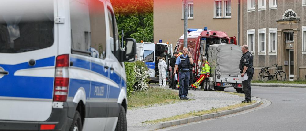 Polizeibeamte und Kriminaltechniker stehen vor dem mutmaßlichen Tatort in Forst in Brandenburg. 