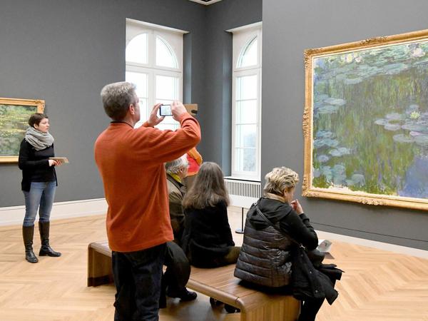 Besucher betrachten im Museum Barberini das Bild "Seerosen" von Claude Monet.