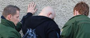 Mega-Polizeibeamte durchsuchten einen Teilnehmer eines Neonazi-Aufmarsches im brandenburgischen Halbe.